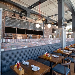 Interior of Finny's Restaurant in Ventura featuring vintage styled leather booths and rustic prohibition era interior design themes