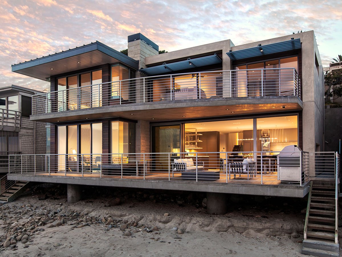 Modern Beach House - Contemporary beachfront residence featuring floor-to-ceiling glass doors that connect interior spaces with the oceanfront deck.