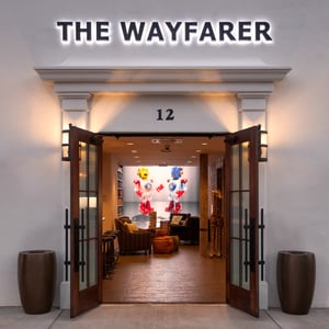 Entry door to the Wayfarer Hotel lobby with exciting back light graphic wall in the background