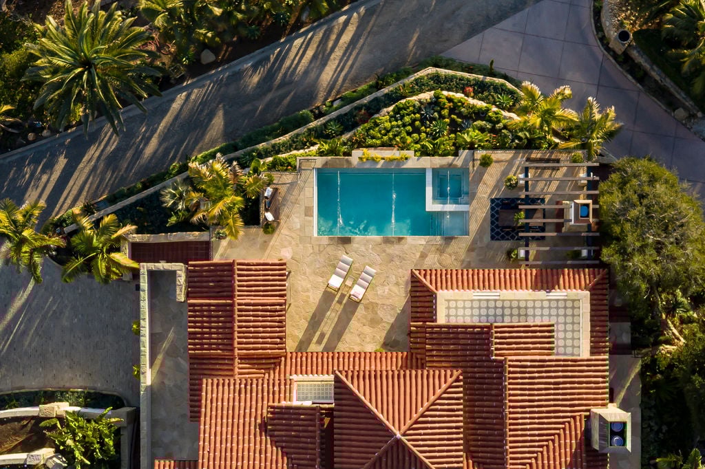 Bird’s-eye view highlights the symmetrical layout and lush landscape of this Spanish Colonial Revival inspired traditional home.