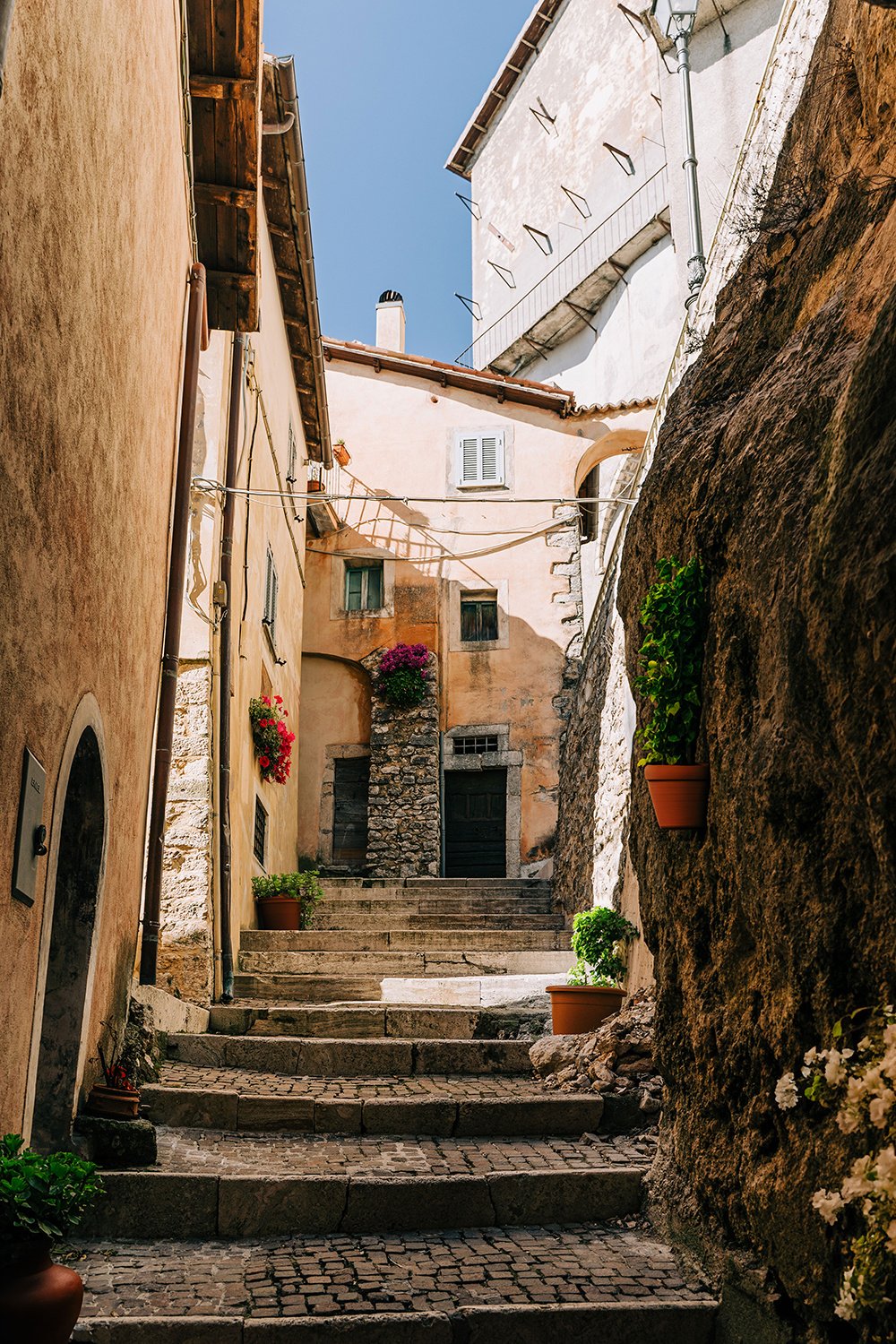 Stone-stepped passage in a historic Mediterranean village inspires the Riviera Residence’s architectural procession and heritage detailing.
