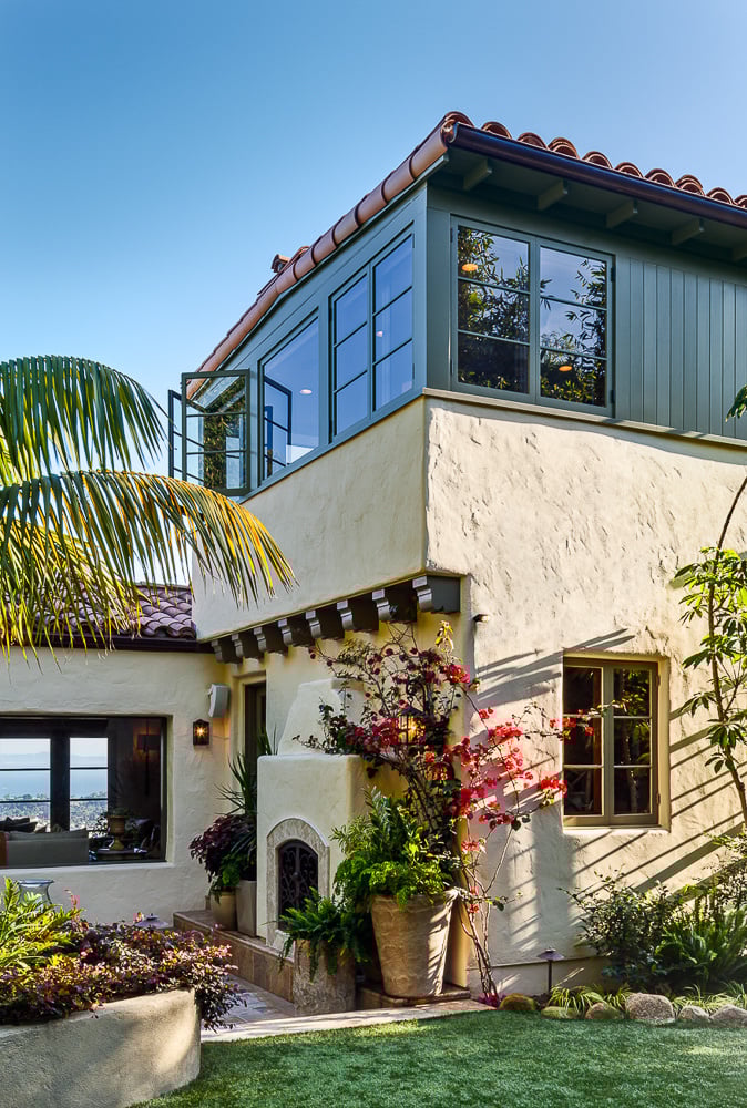 Stucco-clad exterior with terracotta roof and fireplace reflects traditional home design and enduring architectural heritage.