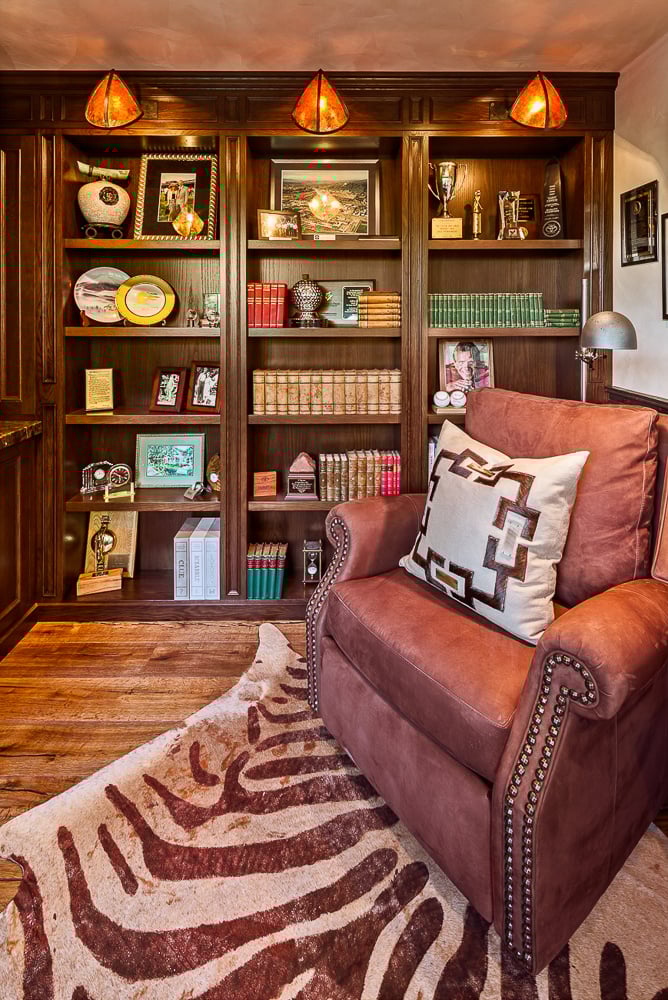 Warm-toned library with detailed millwork evokes the character of traditional home design and historical influences.