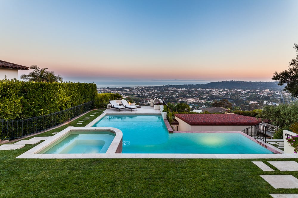 Tiered pool design maximizes hillside views while harmonizing with the site's architectural heritage.