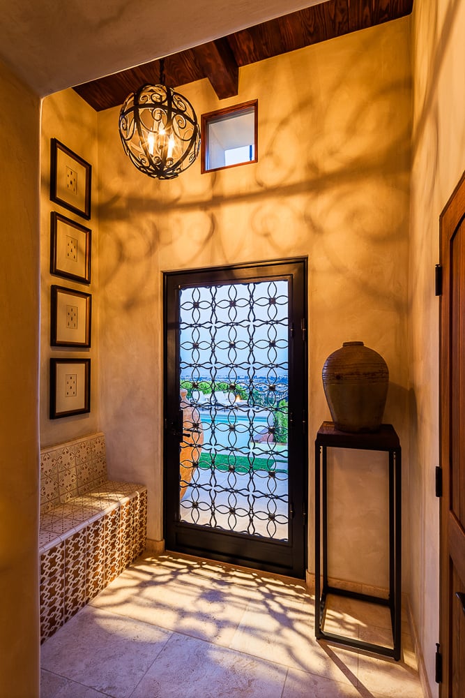 Mediterranean-style entryway with custom ironwork and warm lighting reflecting traditional home design and historic architectural charm.