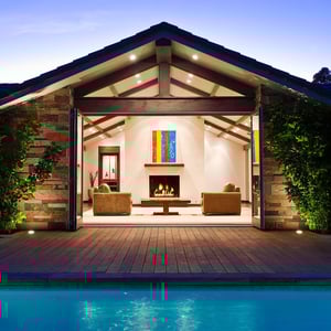 Photo of outdoor and indoor living space with pool in front and beautiful entry 