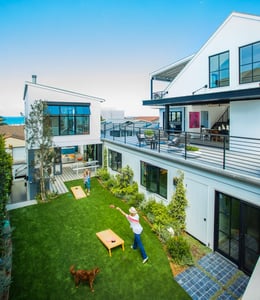 A woman plays with her children in a sunken residential garden nestled in a contemporary residential compound 