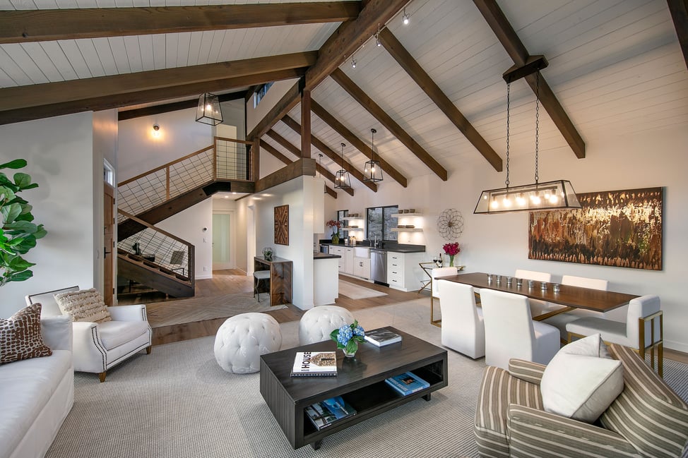 Sophisticated main living and kitchen space featuring vaulted ceilings and luxury finishes, a product of strategic residential remodeling.
