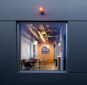 square window with an orange interior wall and black outside modern wall building featuring a light outside
