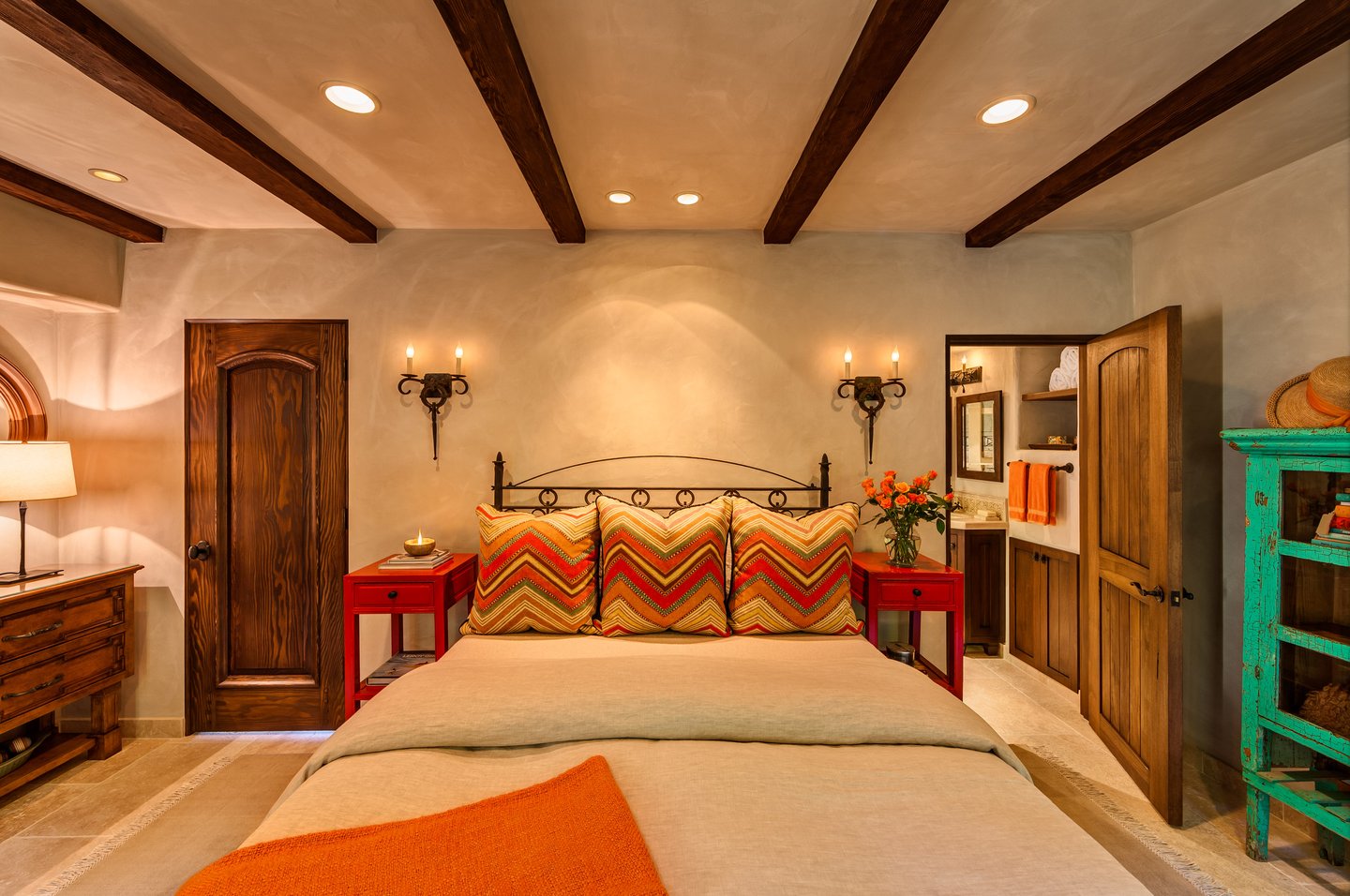 Front view of bedroom with antique furniture and wood ceiling beams.