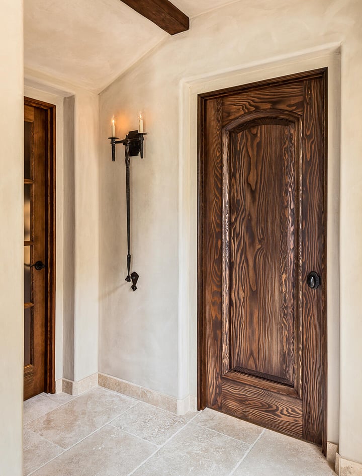 Entryway wooden door detailing and metal light fixture.