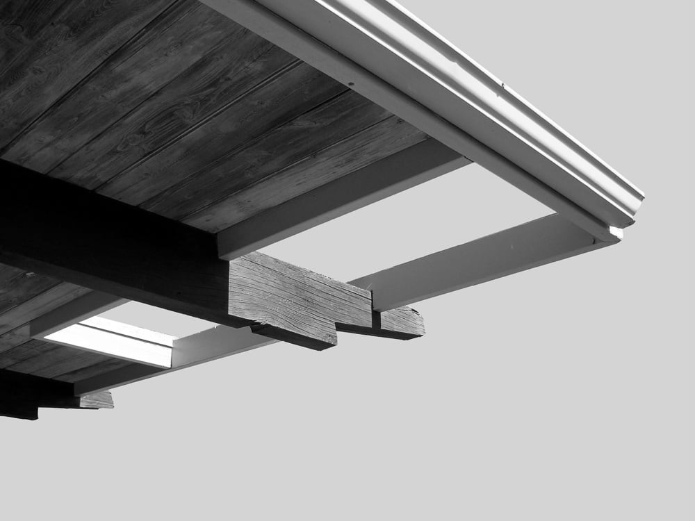 Underside view of extended roof overhangs showcasing exposed rafters typical of mid-century modern design.