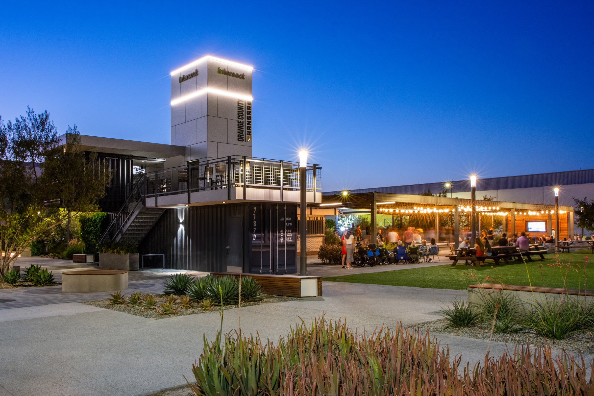 The Pavilion glows at night, showcasing its modular construction and its role as a central amenity on the Intersect campus.