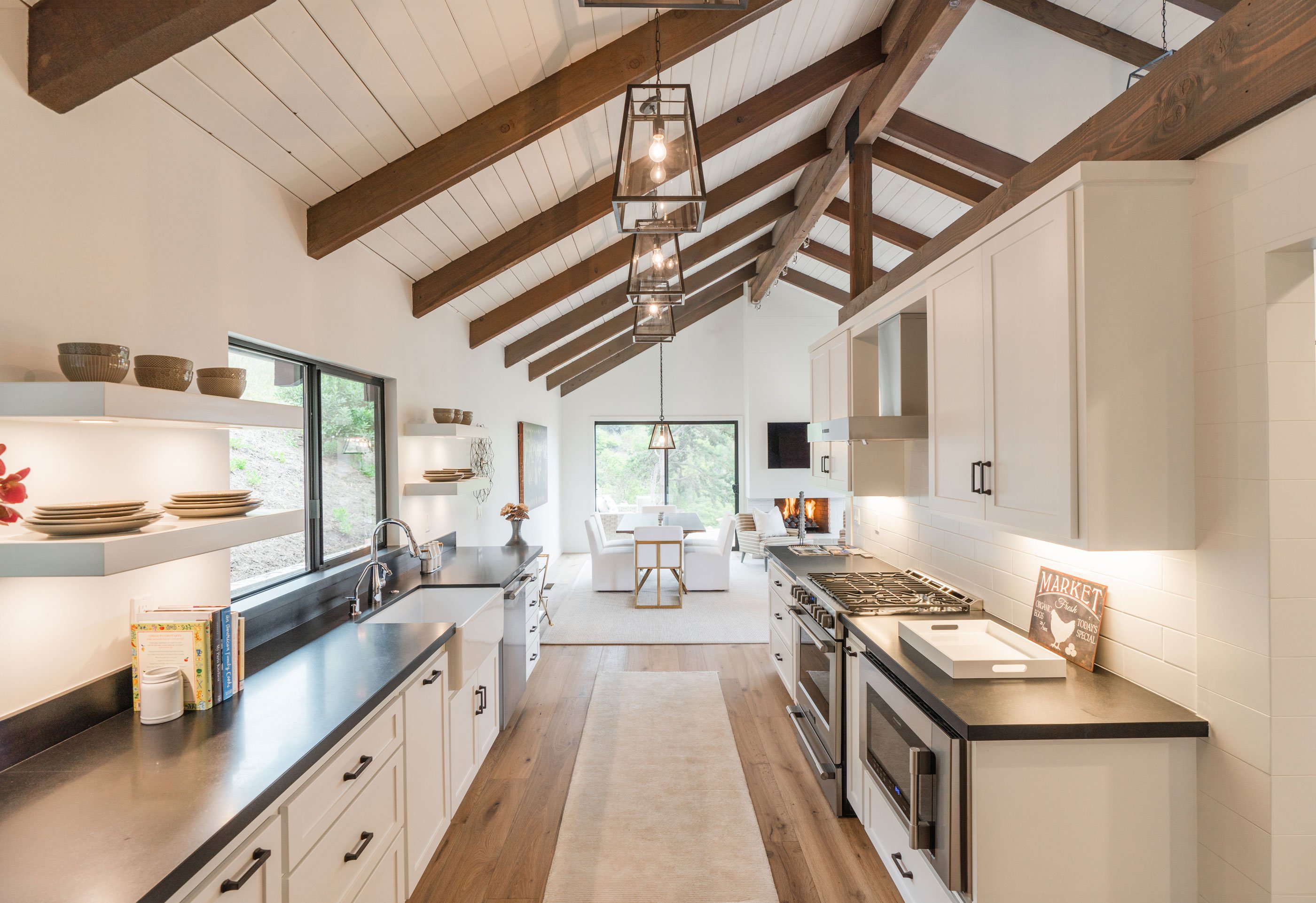 Sleek galley kitchen in a modern open concept layout, emphasizing clean lines and continuity between cooking and dining areas.