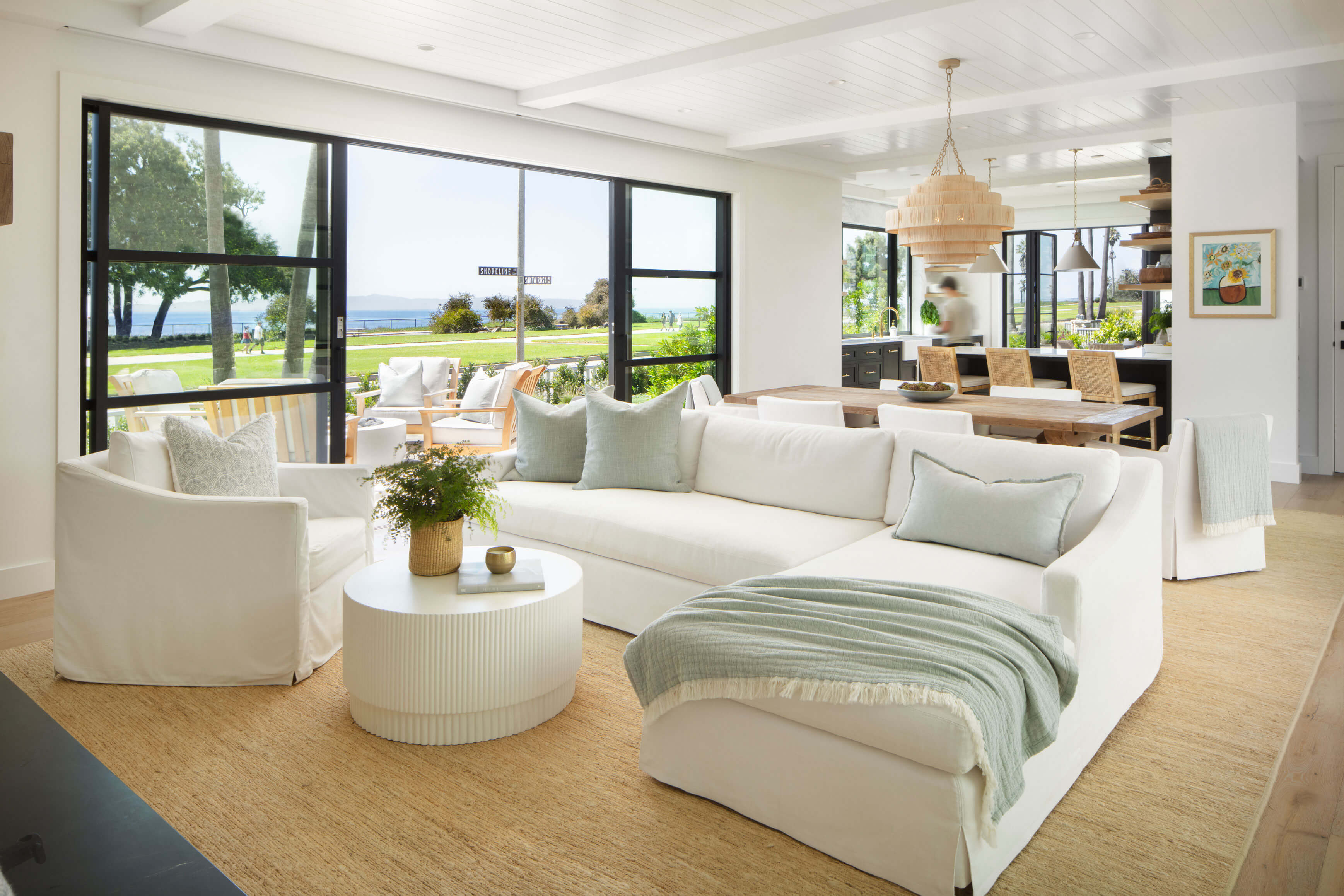 Open living room with large windows and coastal views reflecting traditional interior layout within a two story home.