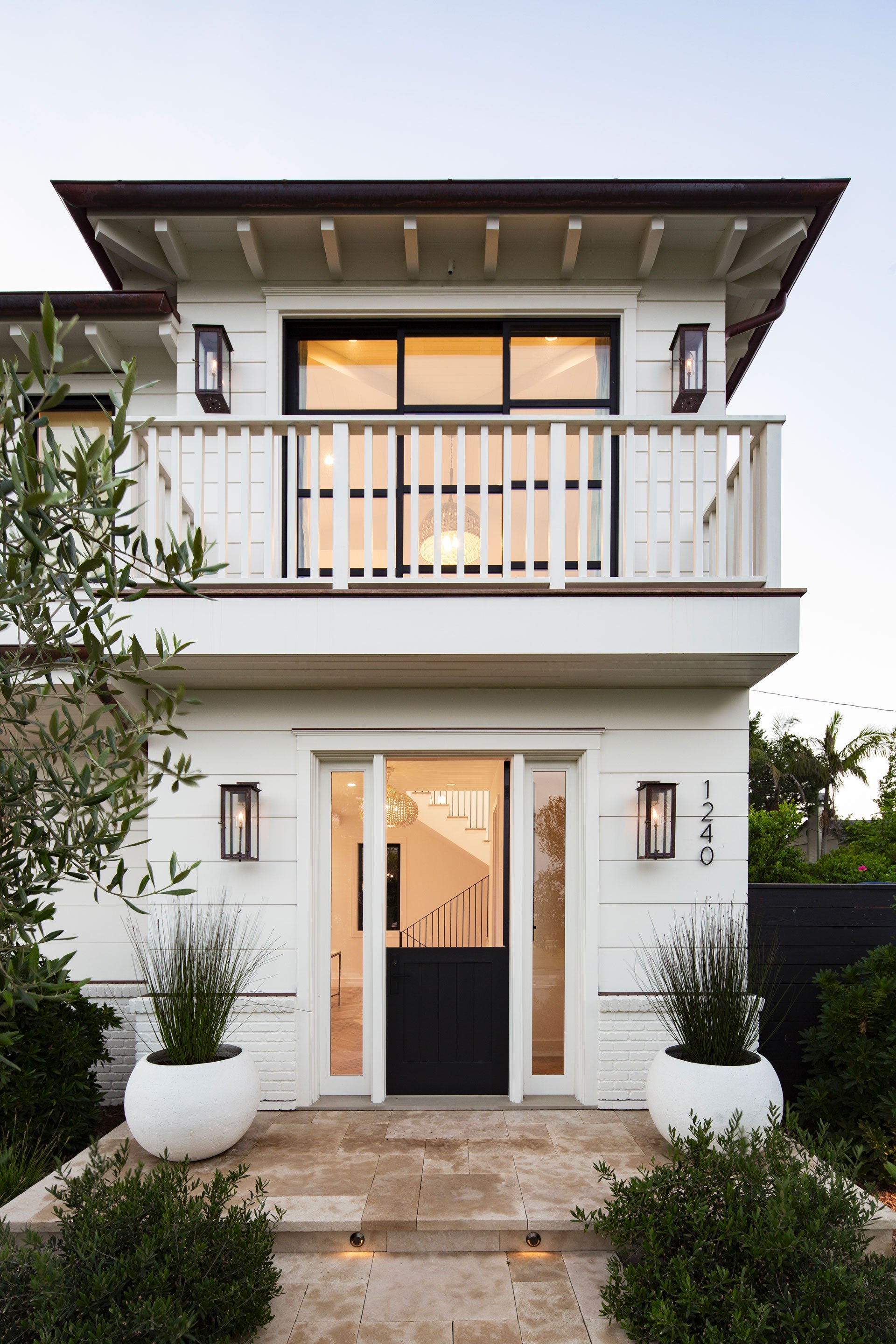 Entryway detail of a traditionally styled two story home with symmetrical front porch and Dutch door.