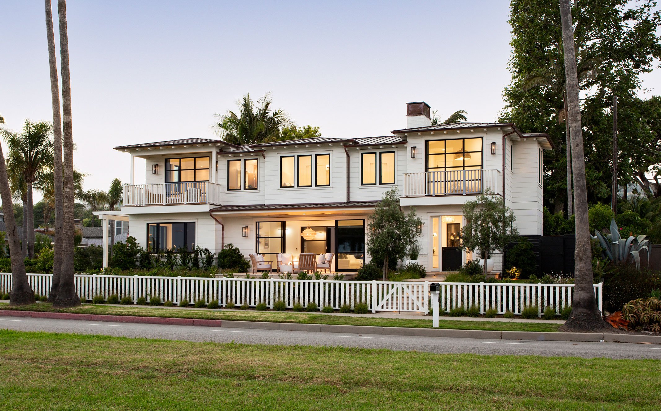 Front exterior of Shoreline Residence with white siding and dual balconies showcasing traditional two story house design.