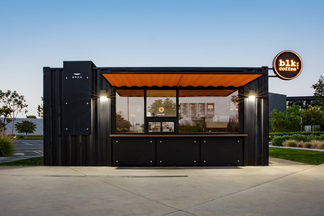Front view of the VKCC modular coffee kiosk with custom orange canopy and compact footprint.