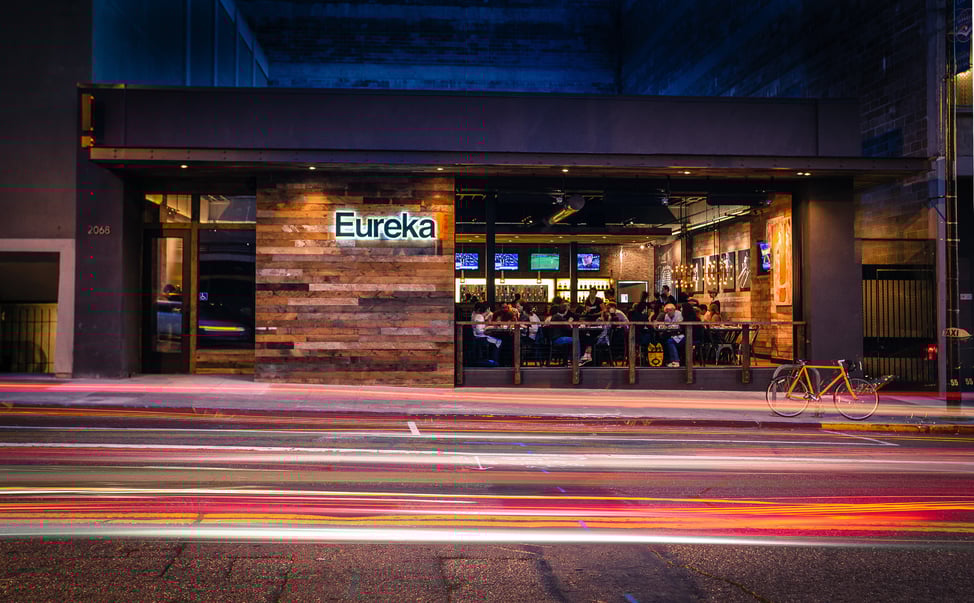 Street view of Eureka! restaurant in Berkeley, CA, featuring a reclaimed wood facade and active nightlife design.