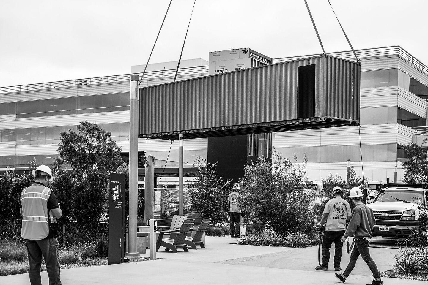 Shipping containers are craned into place during the on-site installation of the Pavilion.