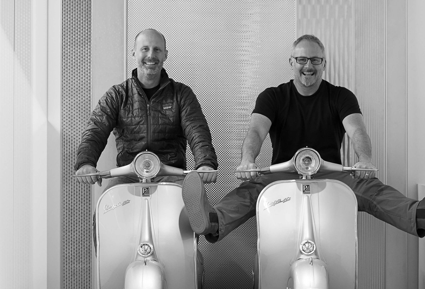 Architects Clay Aurell and Josh Blumer pose for a photo sitting on vintage vespa scooters